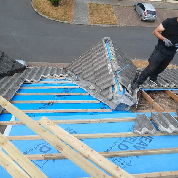 Roofer working on the hip of a concrete tile roof over new membrane, Global Roofing and Guttering, Dublin