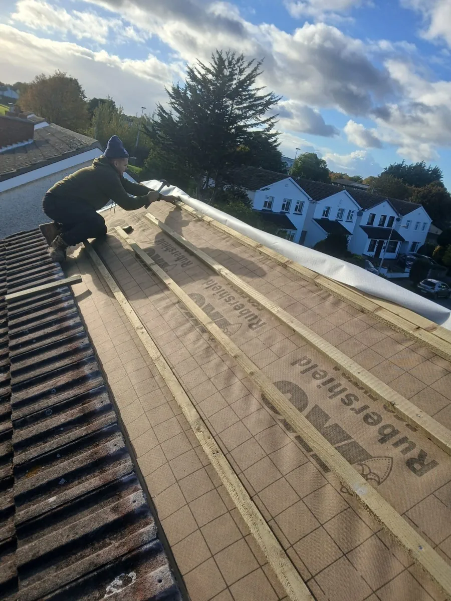 Roofer fixing new battens over breathable membrane on a concrete tile re-roof, Global Roofing and Guttering, Dublin